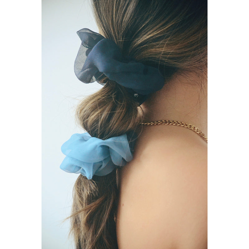 two chiffon silk scrunchies in two different tones of blue on a girls hair 