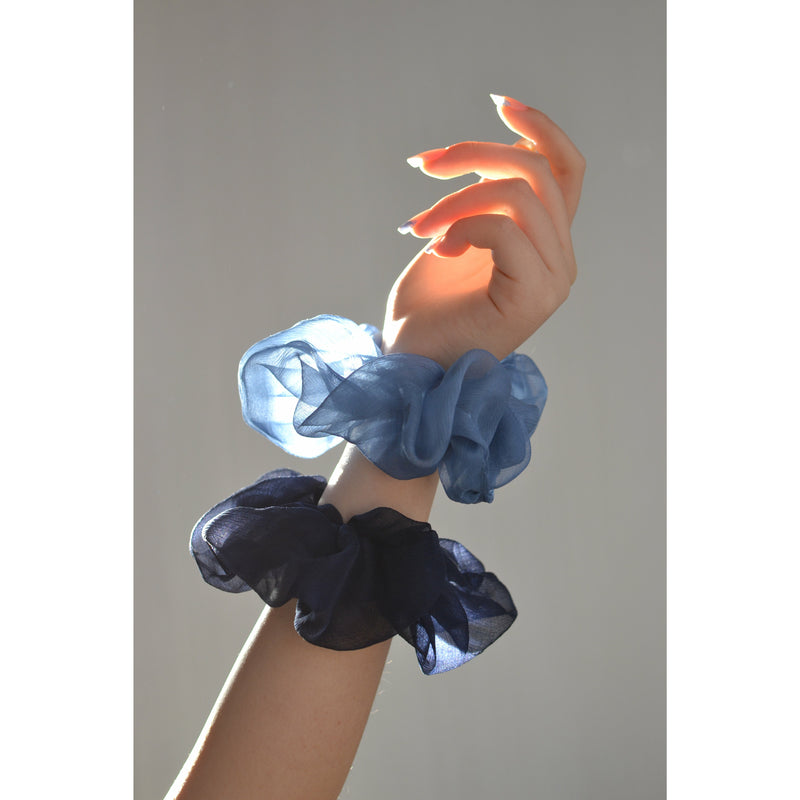 two blue chiffon silk scrunchies on a girls wrist